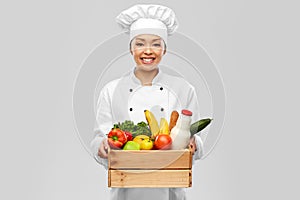 happy smiling female chef with food in wooden box