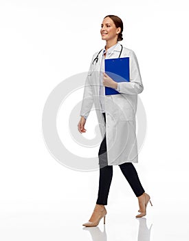 Happy smiling female doctor walking with clipboard