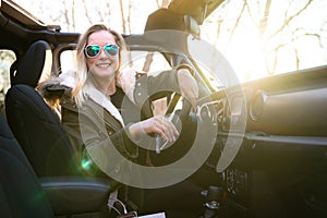 Happy and smiling female driver on a nature and outdoors road trip adventure traveling on a scenic drive in off-road vehicle