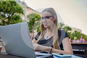 Happy smiling female typing article on netbook