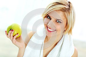 Happy smiling fit woman holding green apple