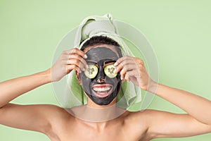 Happy smiling girl applying facial carbon mask portrait - Young woman having skin care cleanser spa day