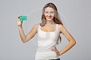 Happy smiling girl in casual clothing, showing blank credit card