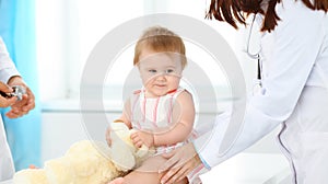 Happy smiling girl-child at usual medical inspection. Doctor and female toddler patient in the clinic. Medicine