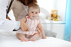 Happy smiling girl-child at usual medical inspection. Doctor and female toddler patient in the clinic. Medicine concept