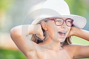 Happy smiling girl with dental braces and glasses.  Orthodontist and dentist concept