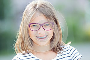 Happy smiling girl with dental braces and glasses. Young cute ca