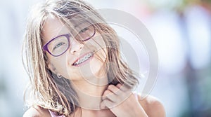 Happy smiling girl with dental braces and glasses. Young cute ca