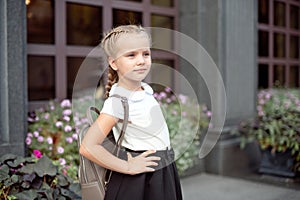 Happy smiling girl is going to school for the first time with bag go to elementary school