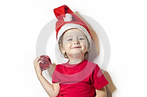 happy smiling girl in holiday clothes and santa claus hat. cute child and christmas decoration