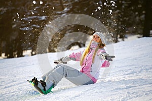 Happy smiling girl with lifted hands on snowboard photo