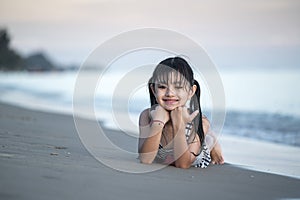 Happy smiling girl lying on the sand beach, summer vacation and relax concept