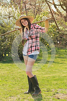 Happy smiling girl posing with a rake