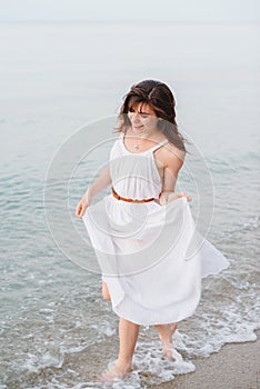 A happy smiling girl in running on the sea shore