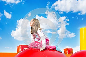 Happy Smiling Girl Sitting on Inflate Castle photo