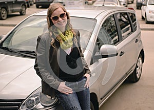 Happy smiling girl standing near the car