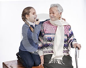 Happy smiling grandmother with granddaughter posing in studio