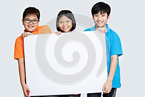 Happy smiling group of kids showing blank placard board.