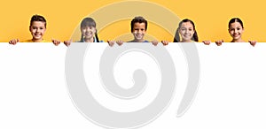 Happy smiling group of kids showing blank placard board