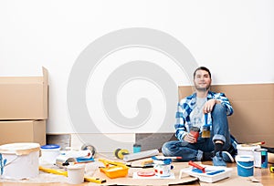 Happy smiling guy relaxing on floor with coffee