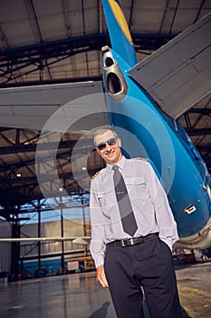 Happy smiling handsome men welcoming each other in the aviation garage