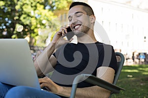 Happy smiling hipster guy having pleasant mobile phone conversation via cellphone
