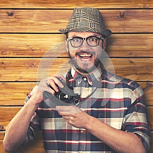 Happy smiling hipster with retro camera in hands