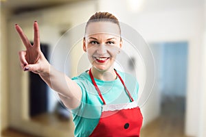 Happy smiling housewife showing peace vistory gesture