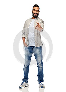 Happy smiling indian man showing ok hand sign