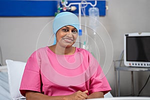 Happy smiling indian recovered breast cancer patient looking camera on bed at hospital - concept of Medical Success
