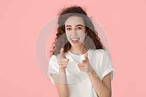 Happy smiling joyful millennial girl pointing fingers at camera.