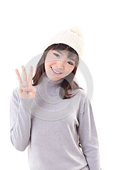 Happy, smiling, joyful woman wearing knit hat, showing 3 fingers