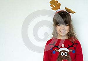 Happy smiling kid in a red knitted pullover with a Santa hat on head isolated on white background.