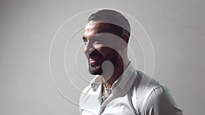 Happy smiling laughing man. Portrait of a smiling latinos man against a gray background. Male emotions faces. Young