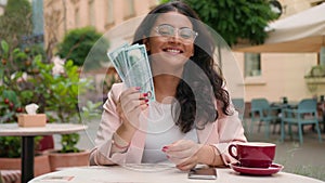 Happy smiling laughing successful Indian Arabian ethnic woman student female girl businesswoman holding show cash money