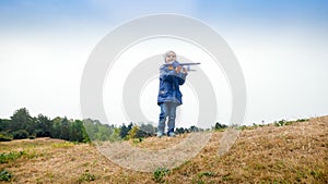 Happy smiling little boy holding and playing with toy airplane on field