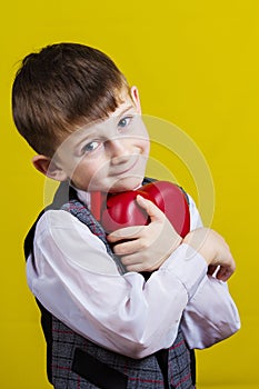 Happy, smiling little boy holding Red heart i