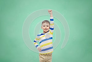 Happy smiling little boy with raised hand