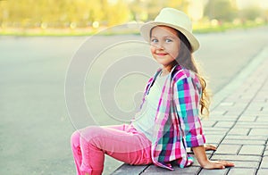 Happy smiling little girl child wearing a summer straw hat, pink plaid shirt