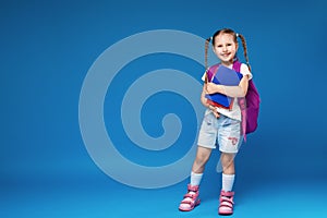 Happy smiling little girl goes to school for the first time