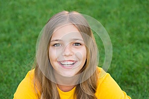 Happy smiling little girl relaxing green grass, sincere emotions concept