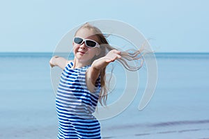 Happy smiling little girl in sunglasses on beach vacation