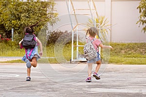 Happy smiling little girls with backpack running to school for the first time. Children are Happy and ready to learn. Back to