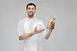 happy smiling male chef with pasta in glass jar