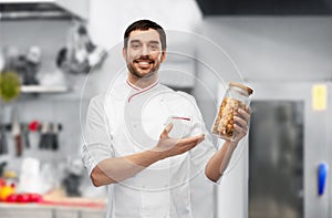 happy smiling male chef with pasta in glass jar