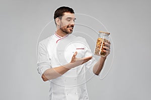 happy smiling male chef with pasta in glass jar