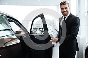 Happy smiling male dealer inviting customers photo