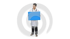 Happy smiling male doctor showing blank signboard and dancing on white background.