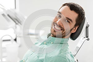 Happy smiling male patient at dental clinic photo