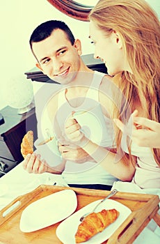 Happy smiling man and positive girlfriend with tasty breakfast